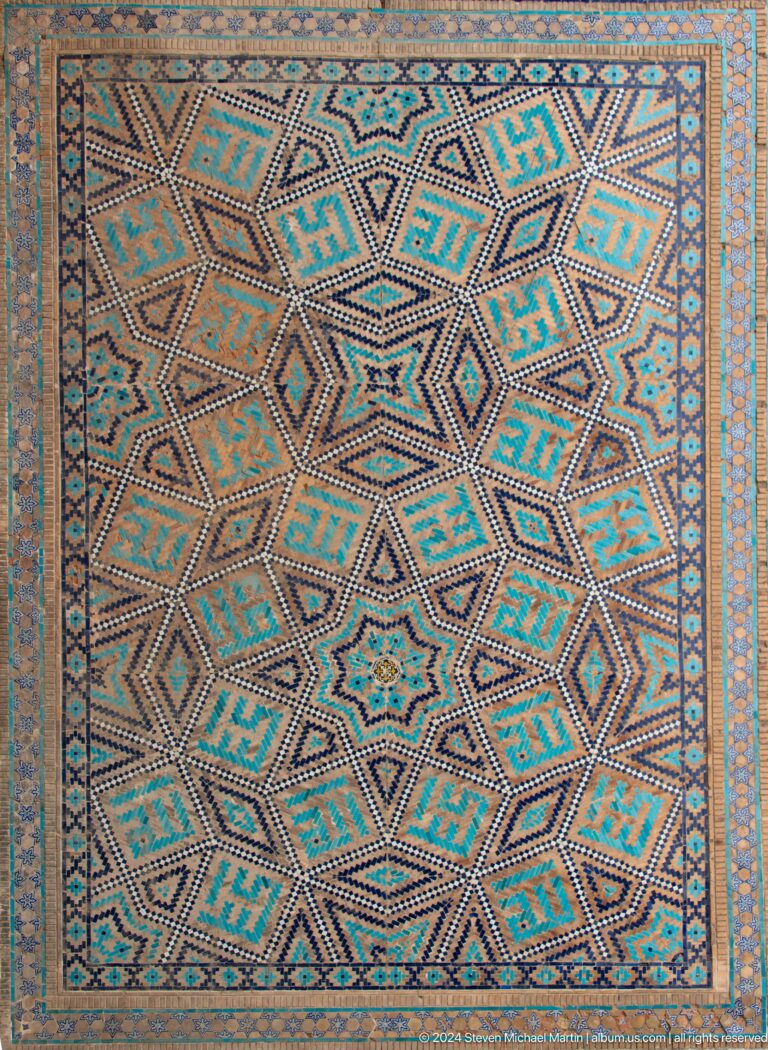 Close view of a turquoise, ochre, blue, and white interlocking star-pattern ceiling.