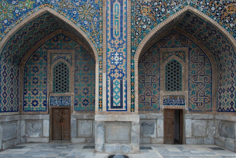 Two tiled pointed arches with wooden doors and small lattice windows.