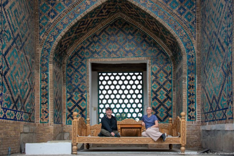 Tiled pointed alcove with a perforated lattice screen and low cushioned platform.