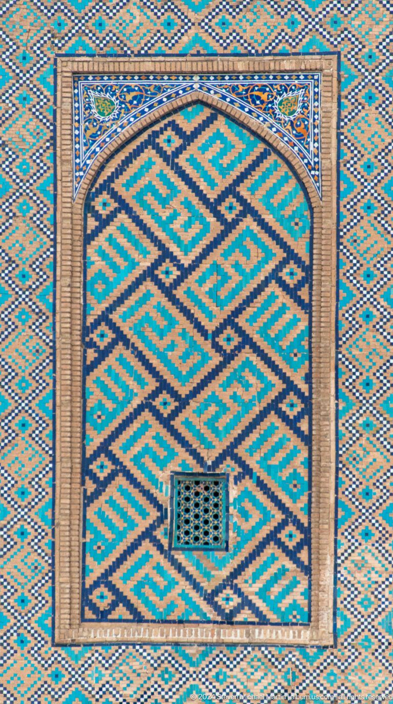 Close-up of angular turquoise and blue tile patterns divided by a pale vertical strip.