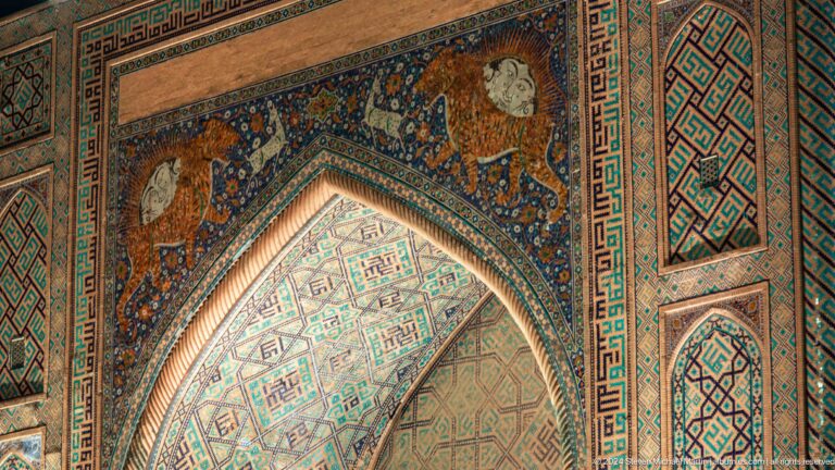 Close-up of Sher-Dor Madrasa's feline, deer, and radiant sun mosaic above the portal.