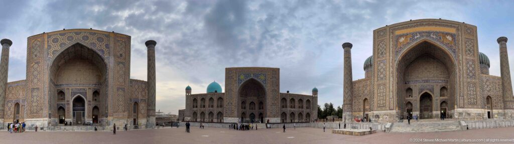 Daytime view of Tilya-Kori Madrasa across Registan Square beneath dramatic gray clouds.