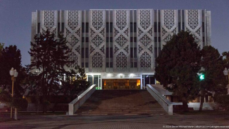 Geometric modernist building facade above broad entrance steps.