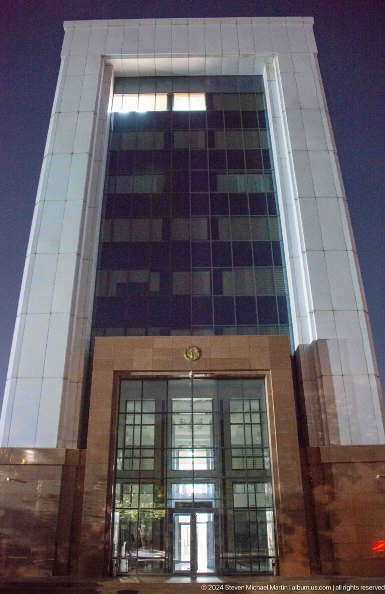 Low-angle view of a tall modern building with dark vertical glazing.