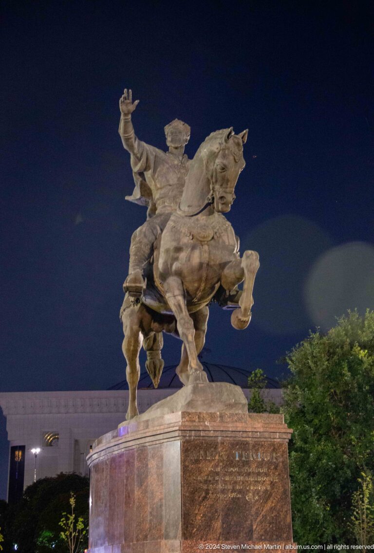 Low-angle night view of the bronze Amir Timur equestrian monument on a rearing horse.