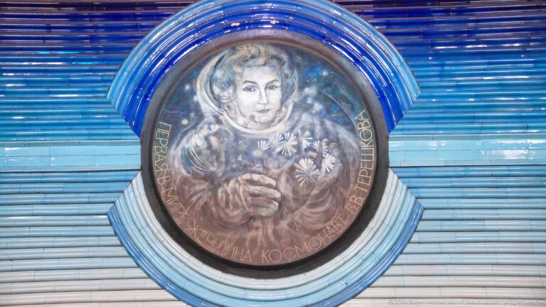 Round relief of cosmonaut Valentina Tereshkova wearing a helmet and holding flowers.
