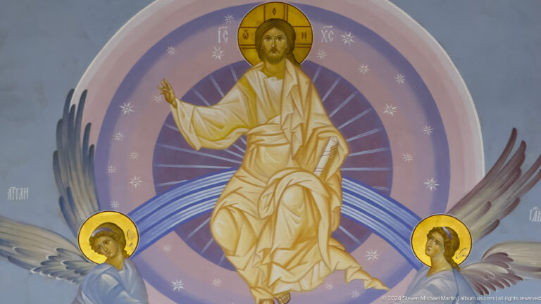 Mural of enthroned Christ raising a hand in blessing within a purple circular halo.