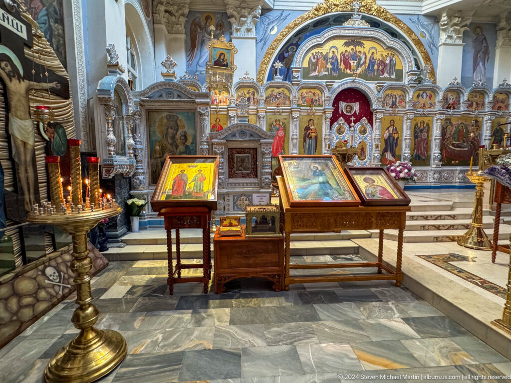 Several icon stands before the gilded iconostasis inside the cathedral.