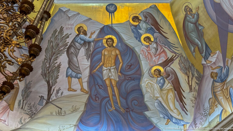Mural of Christ standing in a river as John the Baptist baptizes him and angels watch.