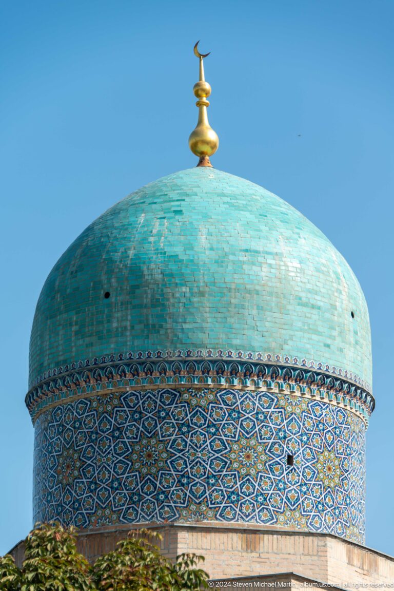 Weathered turquoise tile dome and patterned drum filling the frame at the Khast Imom complex in Tashkent.