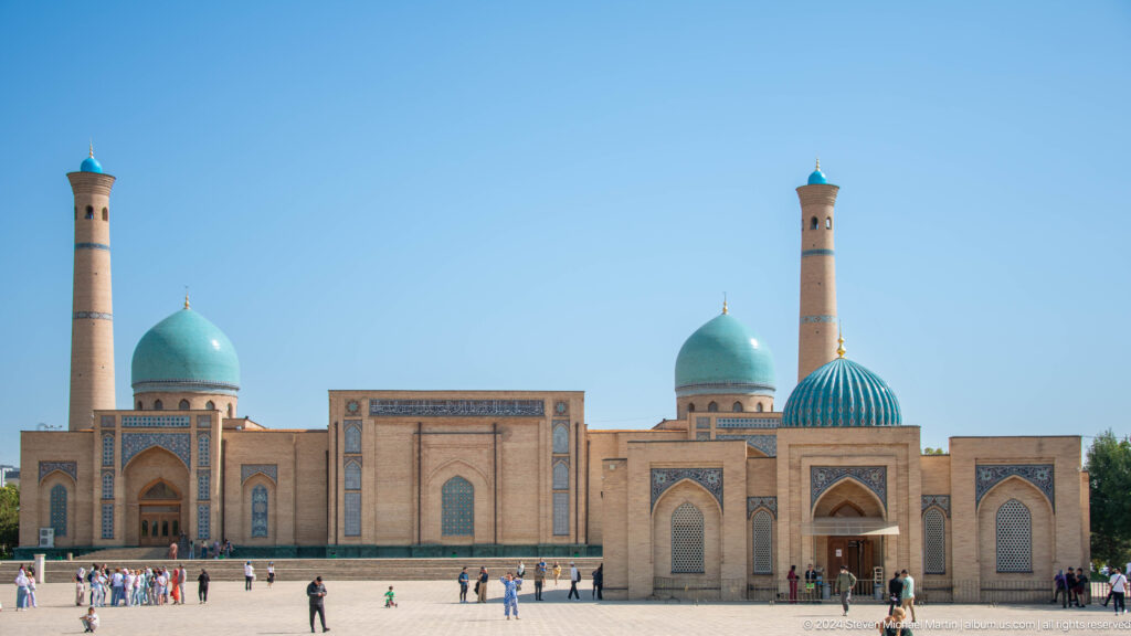 Wide plaza view with domes, minaret, portals, and small visitors at the Khast Imom complex in Tashkent.