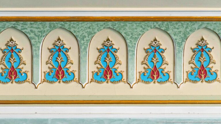 Row of stylized blue-and-red floral motifs beneath pointed pale-green arches at the Khast Imom complex in Tashkent.