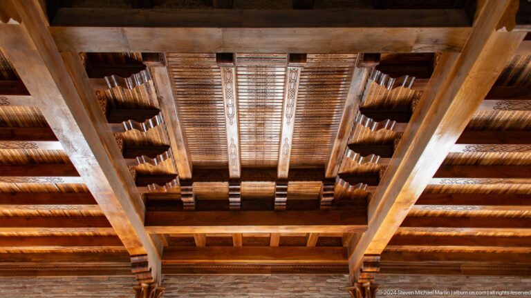 Parallel dark wood beams, painted coffers, and ornamental crosspieces viewed upward at the Khast Imom complex in Tashkent.