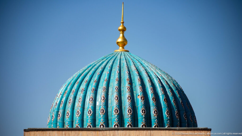 Close crop of blue ribs, repeated floral motifs, and gold finial at the Khast Imom complex in Tashkent.