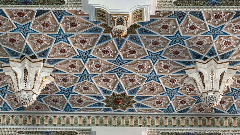 Dense blue, turquoise, red, and white star polygons around a central pendant at the Khast Imom complex in Tashkent.