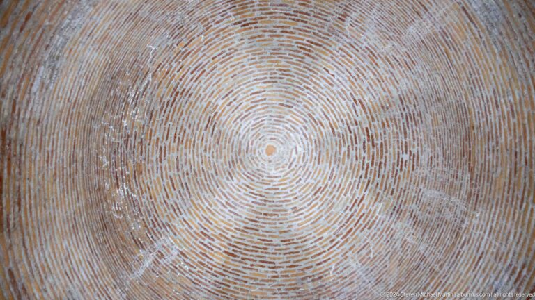 Upward view of a circular brick dome formed by concentric masonry rings.