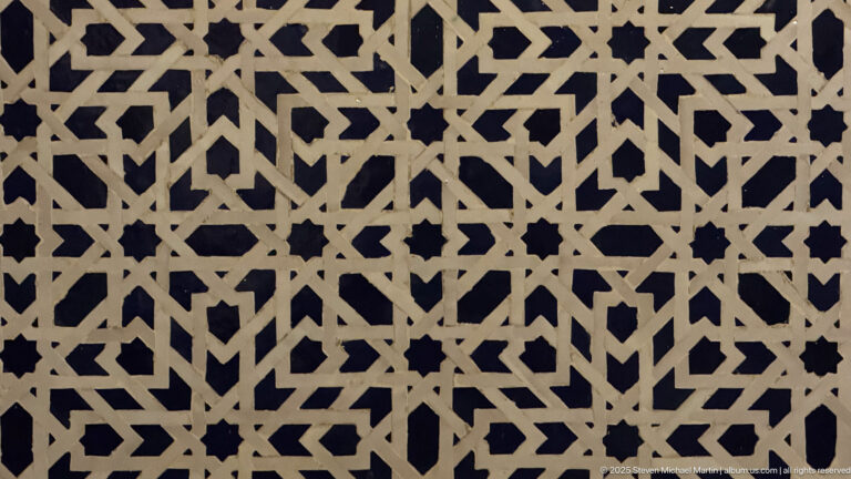 Close-up of pale interlaced geometric bands forming stars and polygons against a dark background.