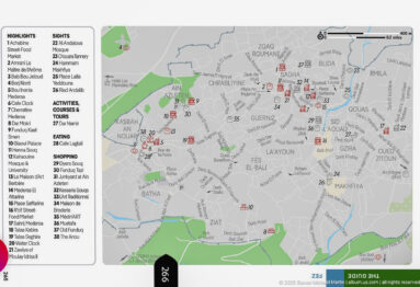 Printed tourist map of Fes with numbered landmarks, street network, neighborhood names, and a long visitor-attraction index.