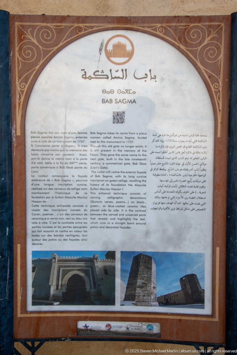 Multilingual heritage information panel with Arabic, French, and English text above photographs of stone towers and fortified architecture.
