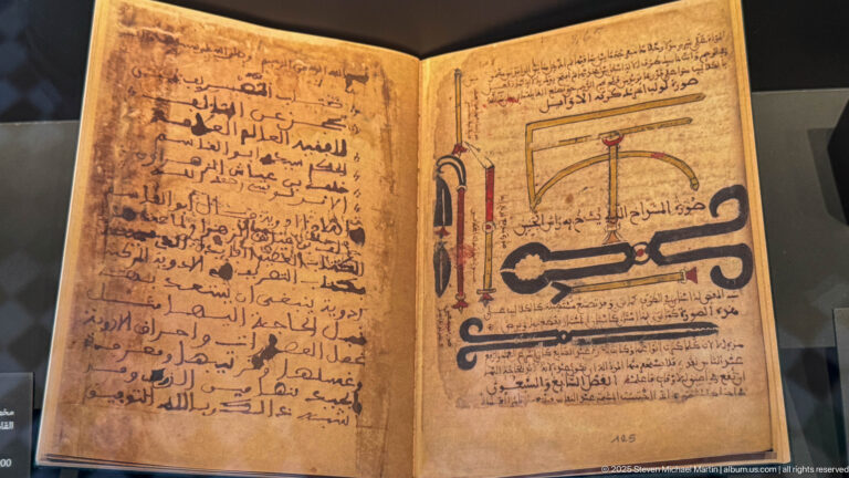 Open Arabic manuscript with dense handwritten text and colored diagrams of several mechanical or technical instruments.