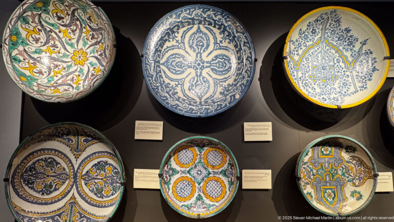 Large wall-mounted ceramic plates with blue-and-white, floral, geometric, and multicolored painted decoration.