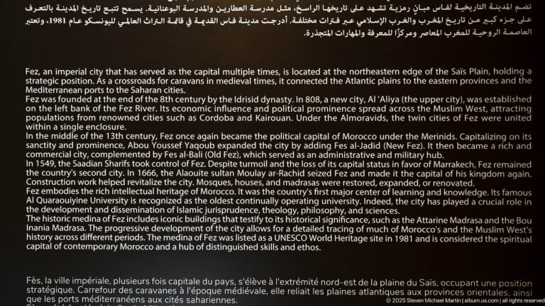 Large black museum panel with English and French text summarizing the history, dynasties, institutions, and cultural importance of Fes.