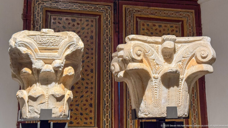 Two large carved architectural capitals displayed side by side, with volutes, leaf forms, and deeply cut ornament.