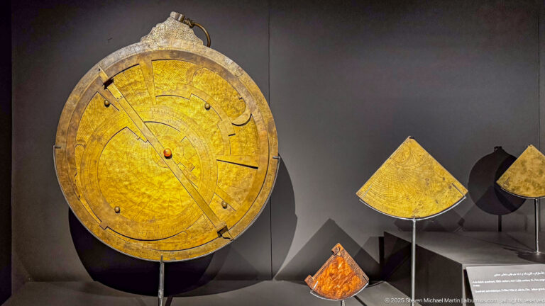 Engraved brass planispheric astrolabe dated 1217–1218 from the Andalusian Mosque of Fes, displayed beside smaller astronomical quadrants.