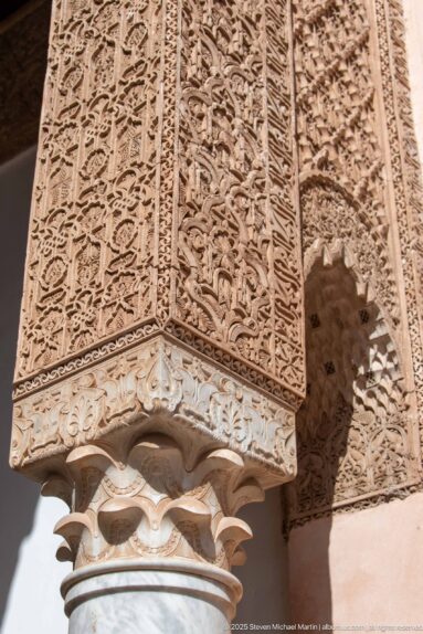 Close-up of a carved stucco pier and lobed capital covered with dense vegetal relief ornament.