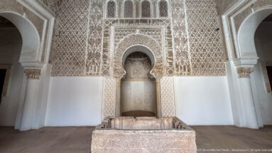 Front-facing ornate wall with central horseshoe niche and rectangular stone feature directly below it.