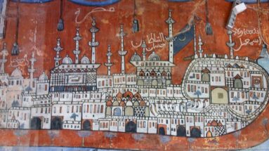 Reddish mural of a city with domes, minarets, towers, gateways, and Arabic inscriptions.