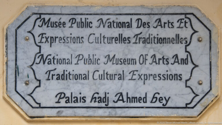 Weathered bilingual plaque identifying the National Public Museum of Arts and Traditional Cultural Expressions at Palais Hadj Ahmed Bey.