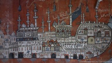 Red-ground cityscape mural filled with minarets, domes, towers, gateways, buildings, flags, and Arabic inscriptions.