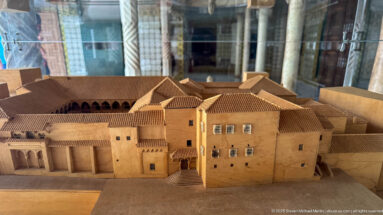 Scale model of Ahmed Bey Palace with pale walls, tiled roofs, central entrance steps, projecting wings, and arcaded sections.