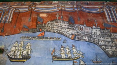 Painted coastal cityscape with fortifications, sailing ships, and a steamship on a wall inside Ahmed Bey Palace.