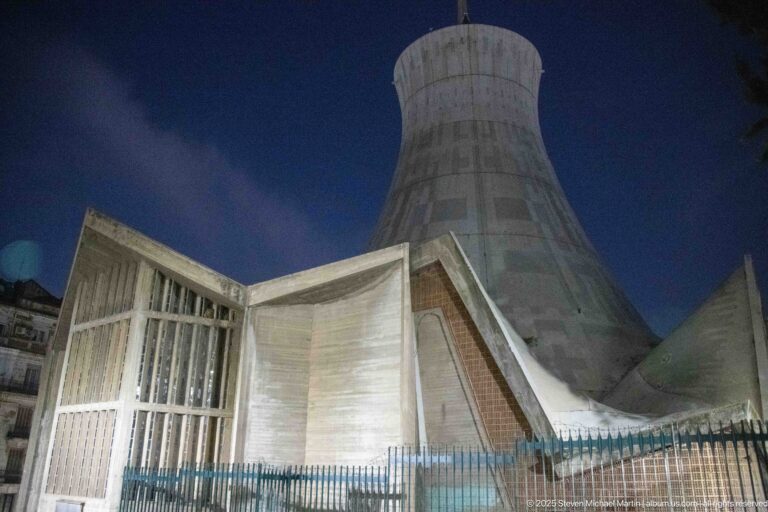 Low-angle night view of the flared concrete tower and angular lower walls of Algiers’ Sacred Heart Cathedral.