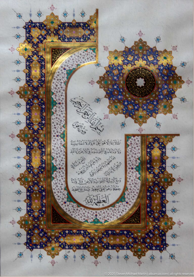 Illuminated Arabic calligraphy in a curved white cartouche surrounded by blue-and-gold ornament and a large radial medallion.