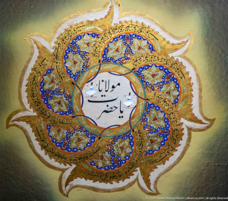 Six-lobed blue-and-gold illuminated medallion with bold Arabic calligraphy in a white central circle.