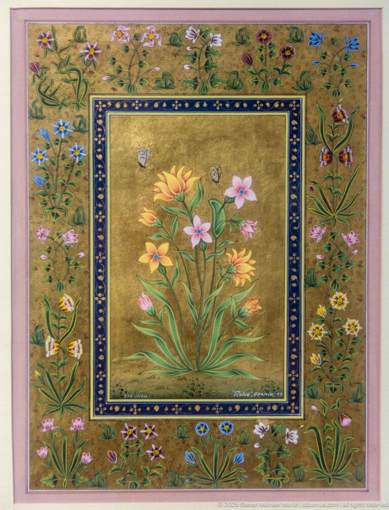 Central bouquet of multicolored flowers on gold, surrounded by a dark frame and a wider border filled with flowering plants and small creatures.