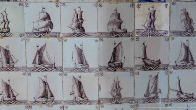 Rows of pale ceramic tiles decorated with repeated sailing ships, showing masts, sails, rigging, and varied hull profiles.