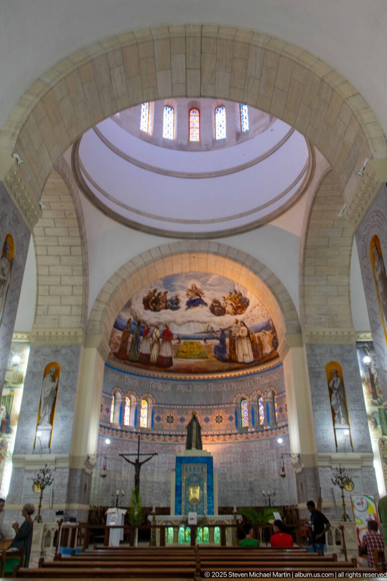 Interior view through large arches toward the altar and decorated apse of Notre-Dame d’Afrique.