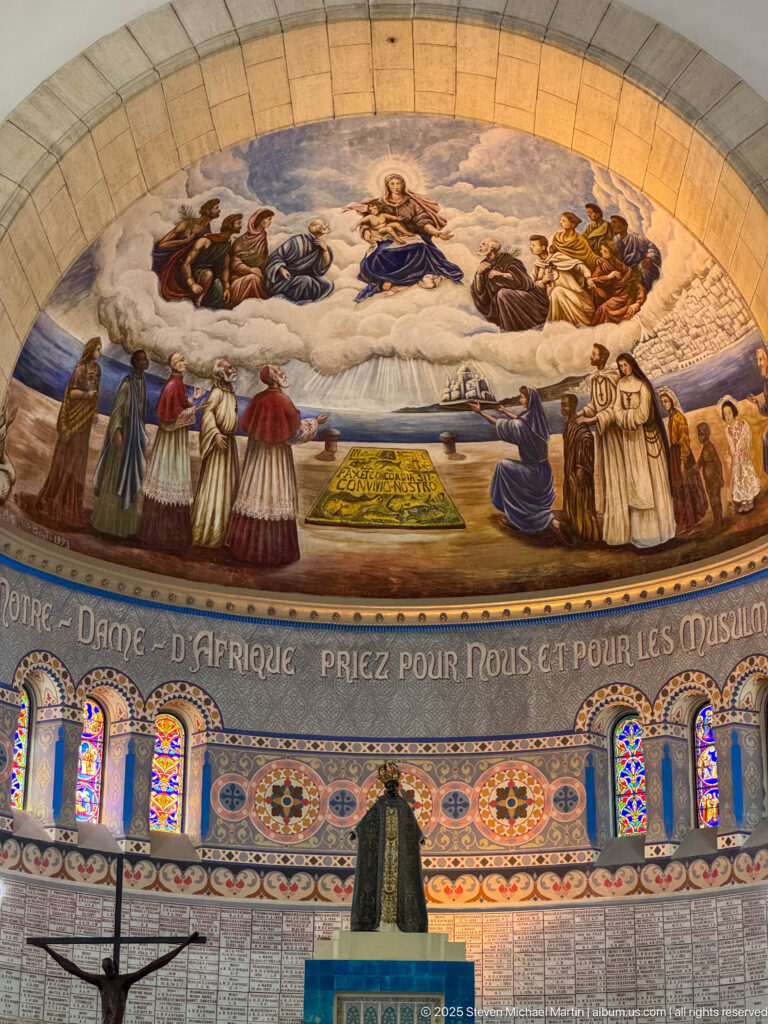 Apse mural above stained glass and the French inscription “Notre-Dame d’Afrique, priez pour nous et pour les musulmans.”
