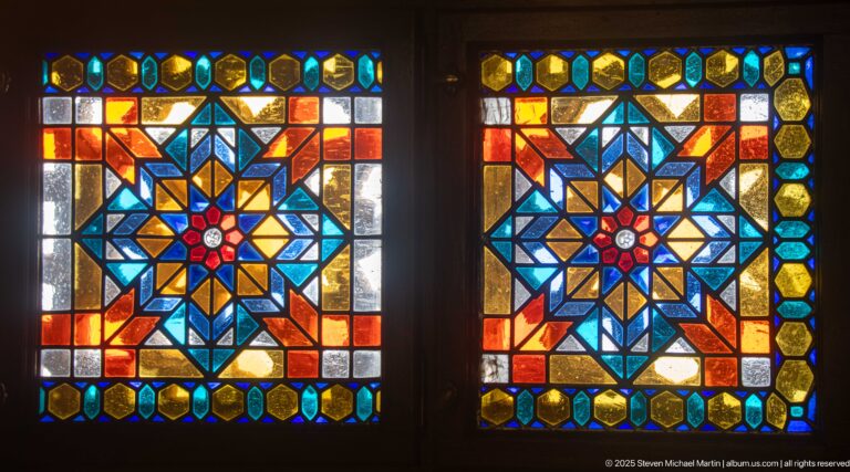 Two square stained-glass panels with radial blue, amber, orange, and red star patterns bordered by smaller colored panes.