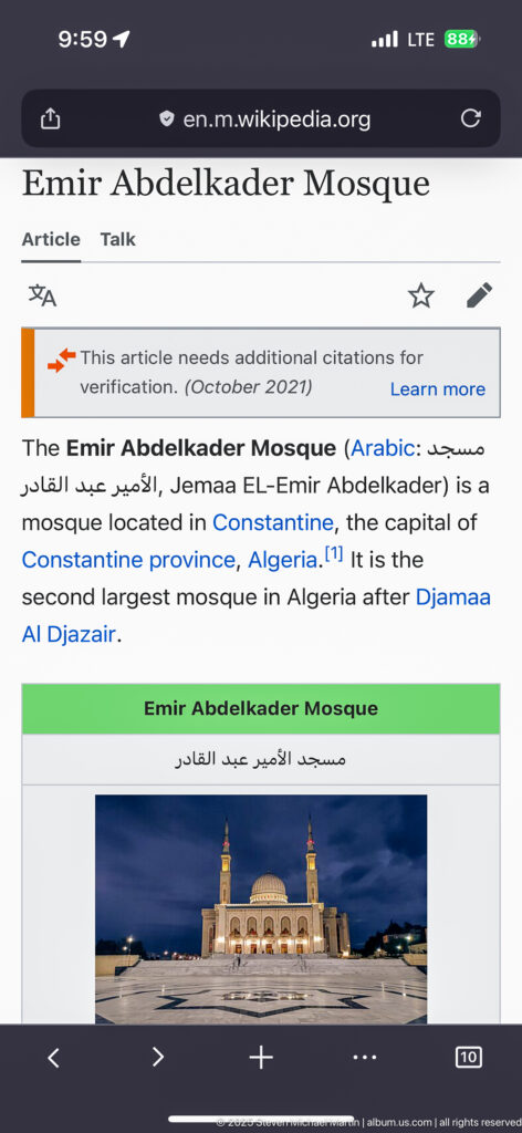Smartphone screen displaying the Wikipedia article for Emir Abdelkader Mosque, with introductory text and a small mosque image.