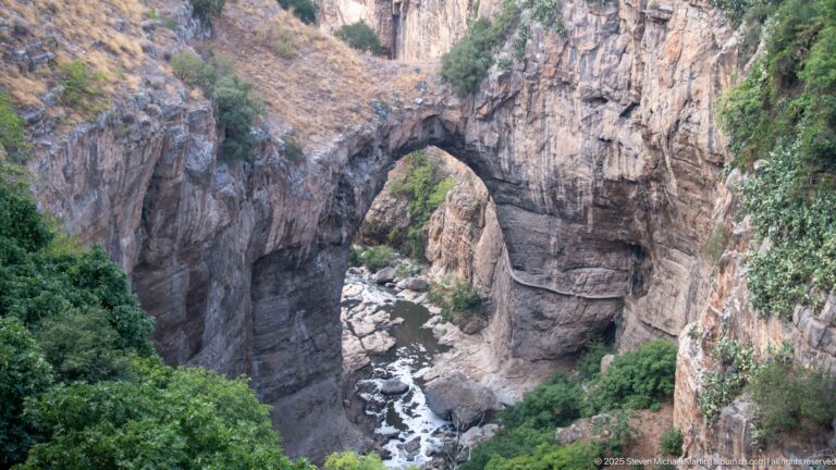 Close view of the Rhumel River and boulders beneath a natural rock arch in Constantine’s gorge.