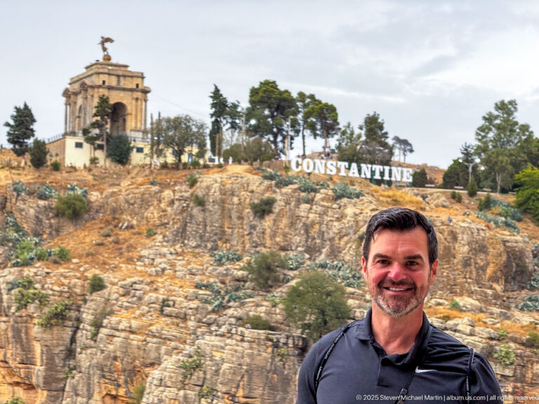 Man in foreground with Constantine’s Monument aux Morts and large CONSTANTINE letters on the cliff behind.