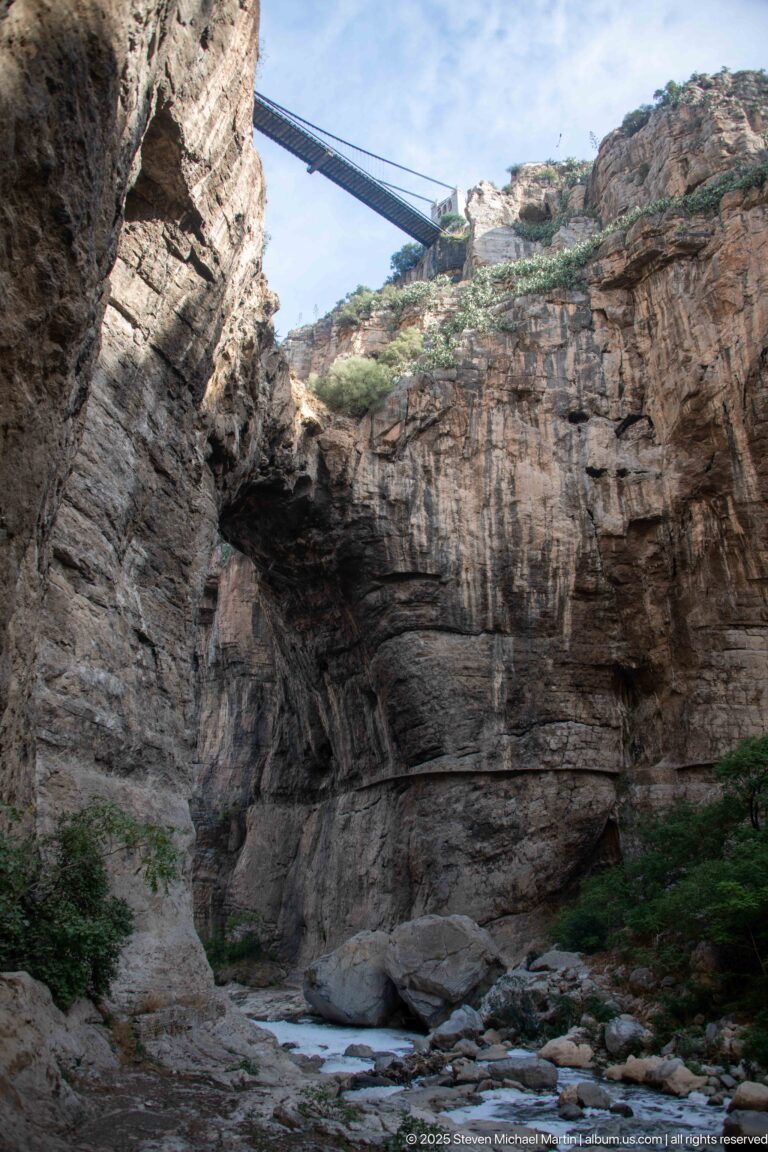 High bridge spanning Constantine’s gorge above a broad natural opening and steep horizontally layered rock walls.