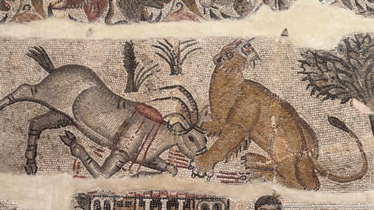 Close-up mosaic detail of two horned animals facing each other amid stylized plants.