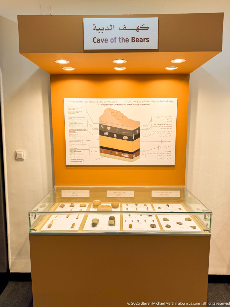 Museum case labeled “Cave of the Bears,” with archaeological objects below an explanatory stratigraphic diagram.