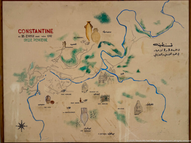 Illustrated bilingual map of ancient Constantine showing rivers, routes, monuments, and a title referring to the Phoenician period.